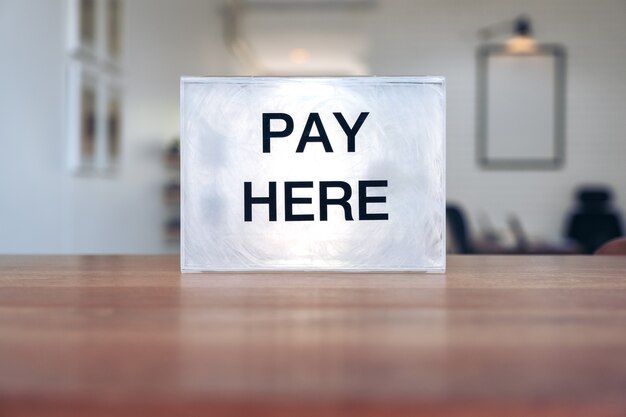 A plastic payment box on wooden table in the shop