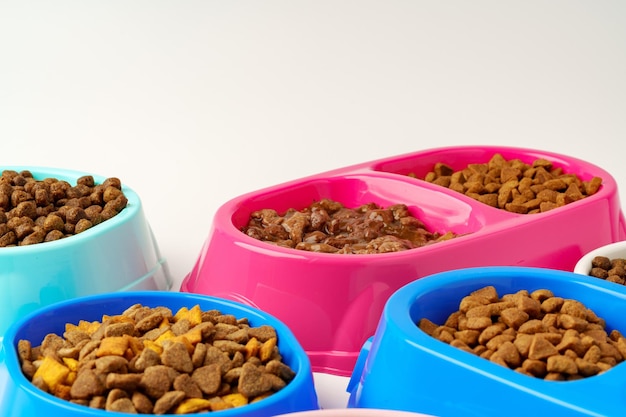 Plastic pet bowls with food isolated on white background