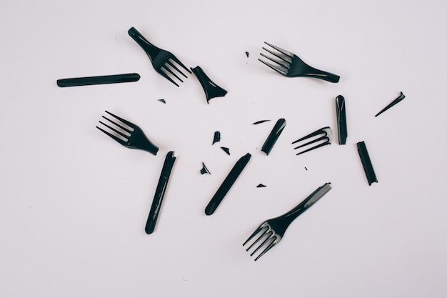 Plastic pollution concept. Plastic free. Scattered broken single-use black forks