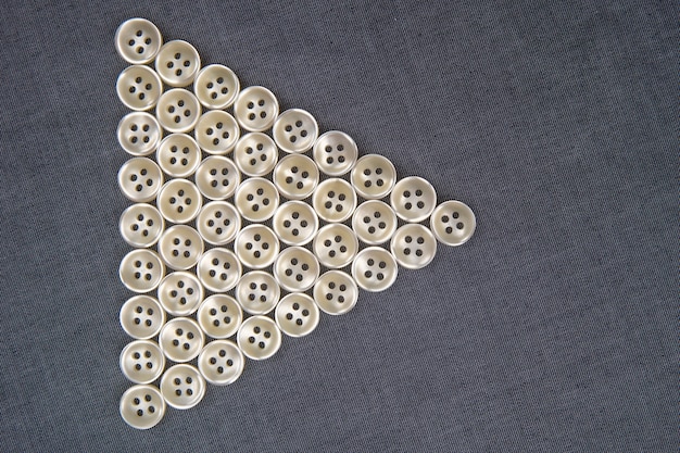 Plastic shiny buttons for clothes on a fabric background.
fashion and clothing. factory industry.