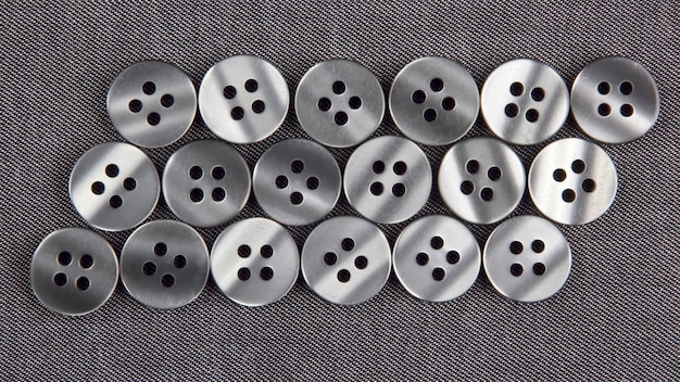 Photo plastic shiny buttons for clothes on a fabric background. fashion and clothing. factory industry