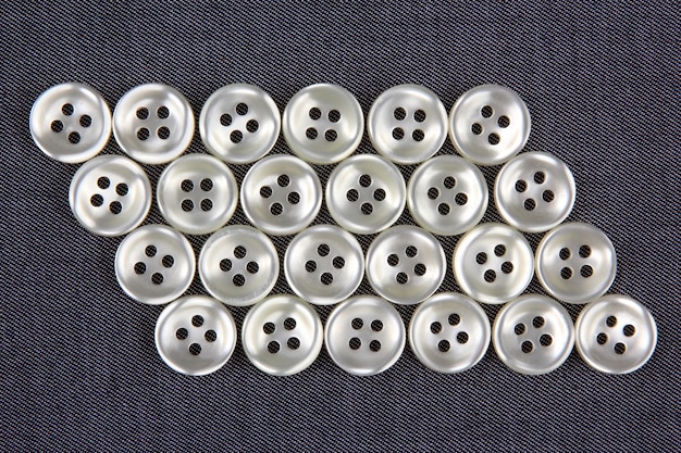 Plastic shiny buttons for clothes on fabric