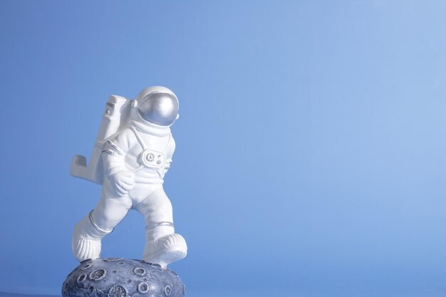 Plastic speelgoedfiguur astronaut op een blauwe achtergrond met kopie ruimte World Space Week 2022 Space and Sustainability Closeup