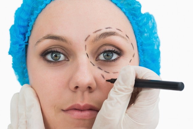Пластический хирург, рисующий вокруг глаз