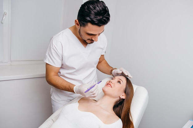 Plastic surgeon making marks by pencil on patient body