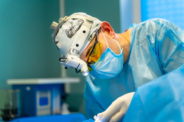 Plastic surgeon performing cosmetic surgery in operating room