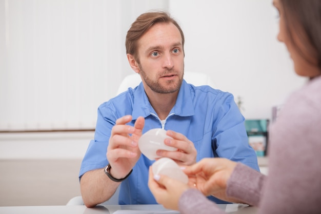 Plastic surgeon showing breast implants to a patient