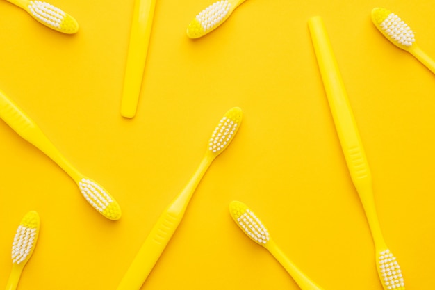 Plastic toothbrushes on yellow background