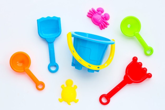 Plastic toys, shovel and bucket for sand on white surface