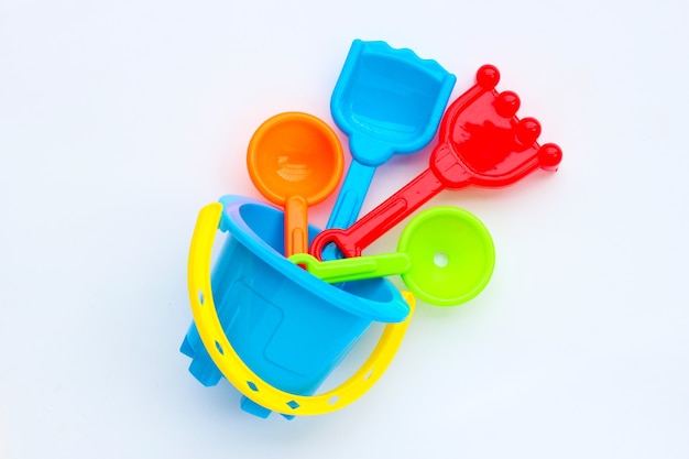 Plastic toys, shovel and bucket for sand on white surface