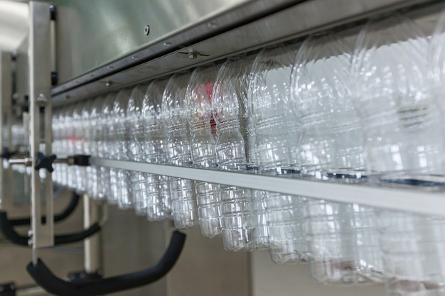 Plastic transparante flessen bewegen op de transportband. Plastic flessen op de transportband