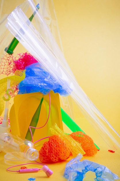 Plastic trash on bright yellow background