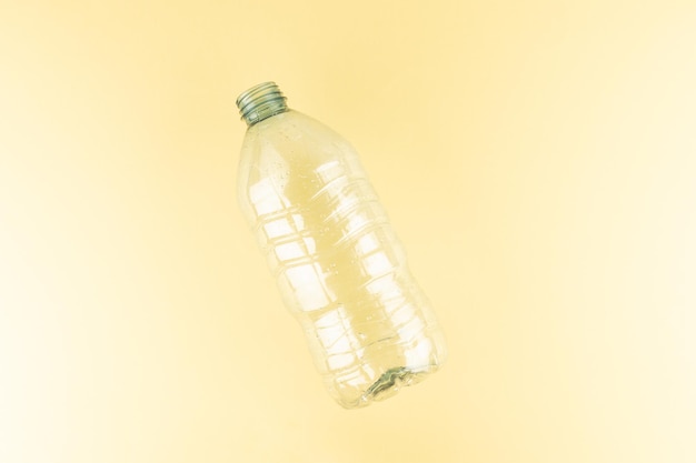 Plastic water bottle on light yellow background