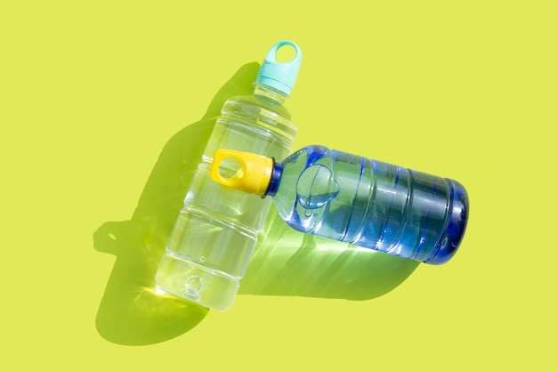 Пластиковые бутылки с водой на зеленой поверхности