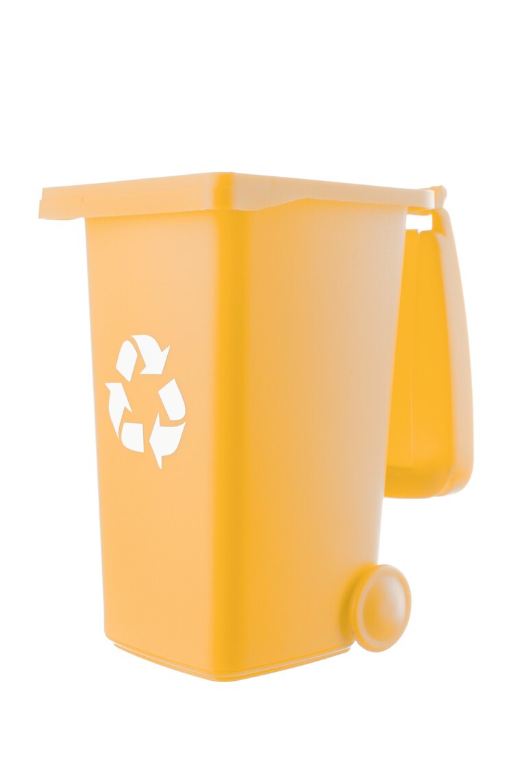 プラスチック製の黄色いゴミ箱は白い背景で隔離できます