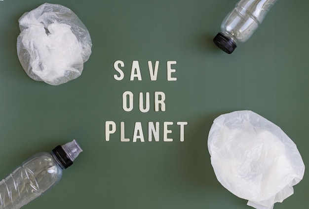 Plastic zakken, flessen en de inscriptie redden onze planeet op een groene achtergrond