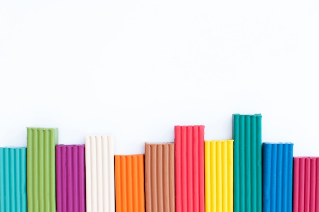 Plasticine columns of different colors on a white background with a place for text