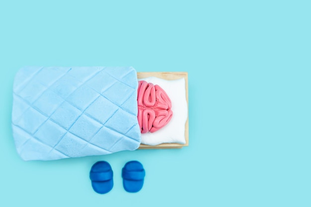 Plasticine pink human brain is sleeping Mind rest concept Blue background