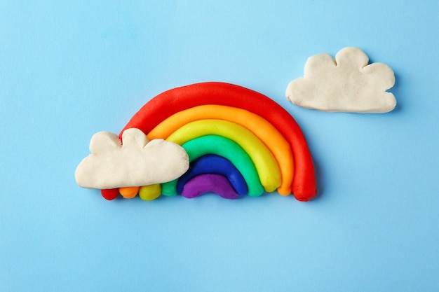 Plasticine regenboog met wolken op kleur achtergrond