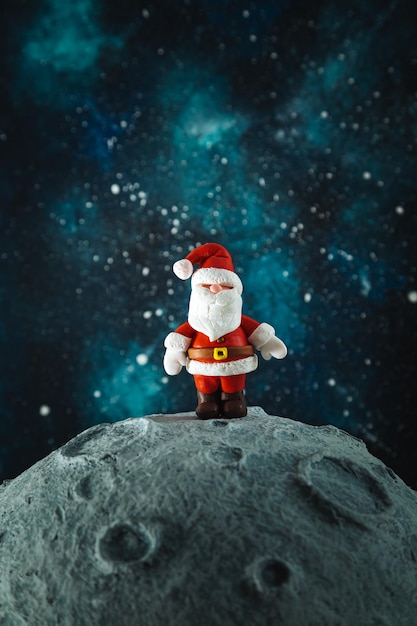 Plasticine Santa Claus on the moon against the background of the starry sky Christmas card