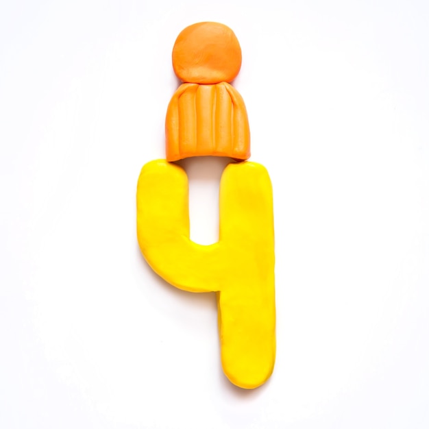 Photo plasticine yellow number 4 four in orange winter hat with pompom on white background