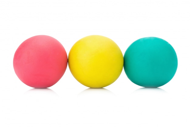Foto plasticineklei drie rode geelgroene bal op witte close-up als achtergrond