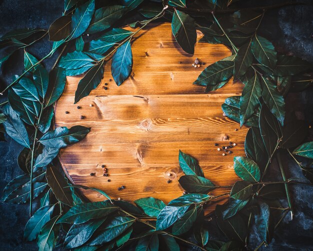 Foto plat lag achtergrond met verse laurus bladeren op houten snijplank.