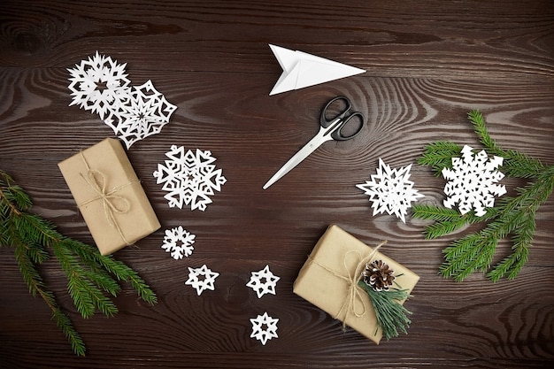 Plat lag compositie voor het snijden van papier sneeuwvlokken op houten tafel