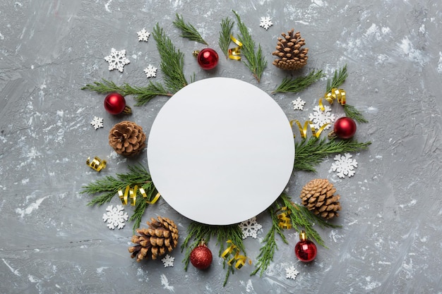 Plat lag kerstcompositie Rond papier blanco dennenboomtakken kerstversieringen op gekleurde achtergrond Bovenaanzicht kopieerruimte voor tekst