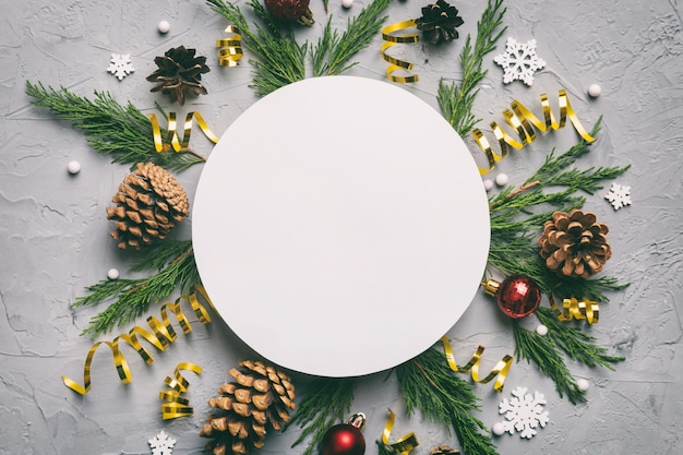Plat lag kerstcompositie Rond papier blanco dennenboomtakken kerstversieringen op gekleurde achtergrond Bovenaanzicht kopieerruimte voor tekst