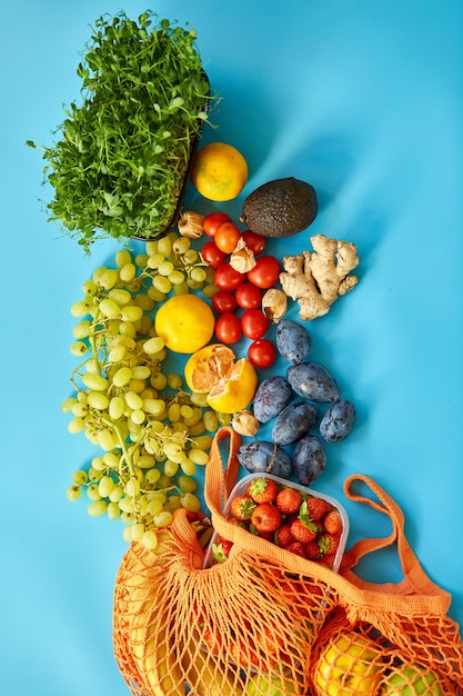 Plat lag Mesh boodschappen doen eco-vriendelijke tas met fruit op blauwe canvas achtergrond Geen afval cconcept Lokale boerenmarkt winkelcentrum bovenaanzicht kopieerruimte Plastic gratis items