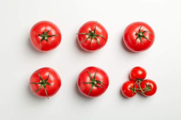 Plat lag met rijpe tomaten op witte achtergrond, bovenaanzicht