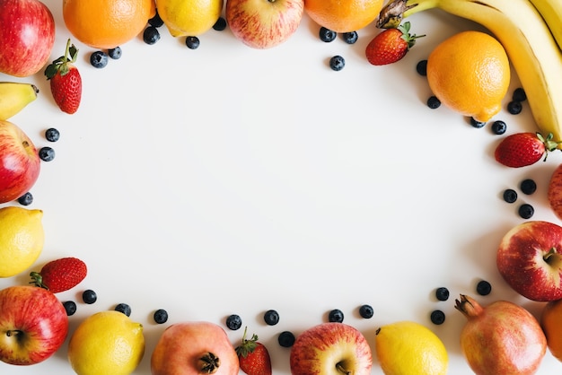 Plat lag met vers fruit en bessen op een witte achtergrond voedselframe plantaardig dieet