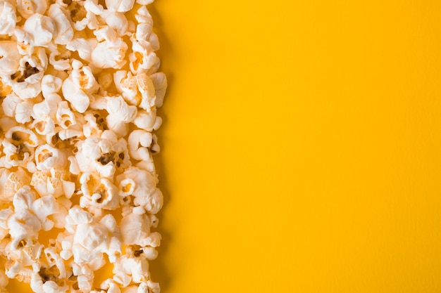 Foto plat lag popcorn op gele achtergrond met kopie ruimte