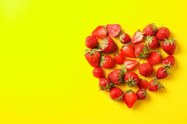 Plat lag samenstelling met aardbeien in de vorm van hart op kleur achtergrond, ruimte voor tekst