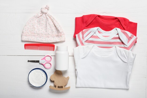 Plat lag samenstelling met babykleding en accessoires op houten achtergrond