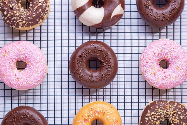 Plat lag samenstelling van gemengde donuts op witte achtergrond.