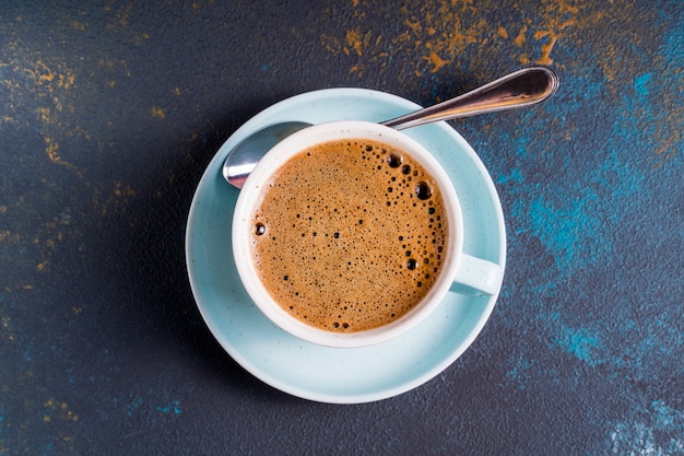 Plat lag zwarte koffie met schuim in een kopje