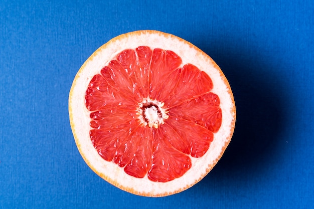 Plat leggen de rauwe verse citrusvruchten - rood oranje op blauwe achtergrond.