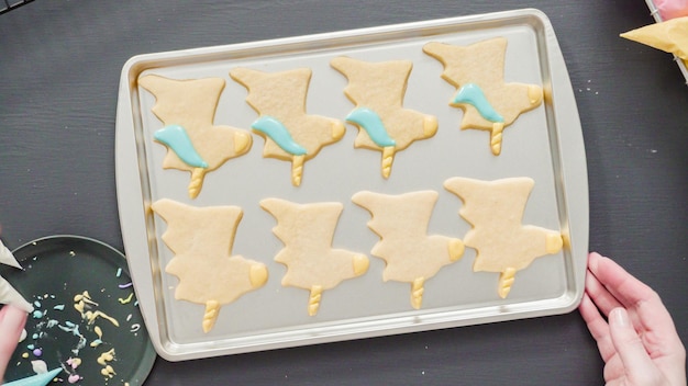 Foto plat leggen. eenhoorn-suikerkoekjes versieren met meerkleurige royal icing.