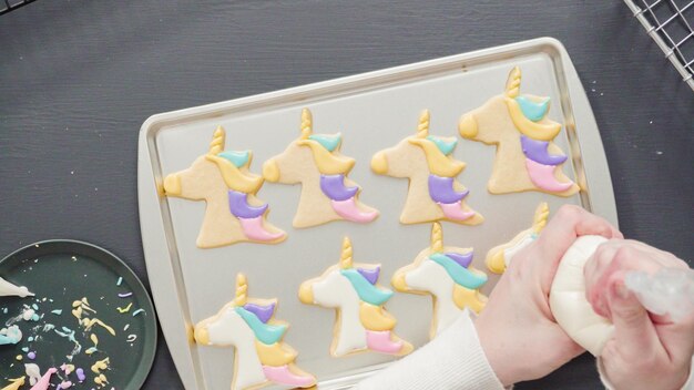 Plat leggen. Eenhoorn-suikerkoekjes versieren met meerkleurige royal icing.