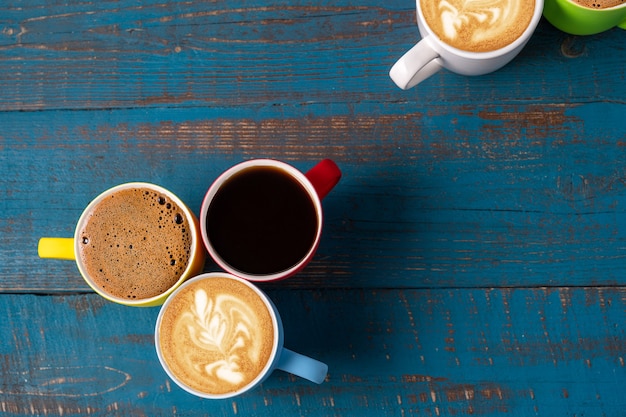 Plat leggen enkele mokken met koffie op blauwe houten