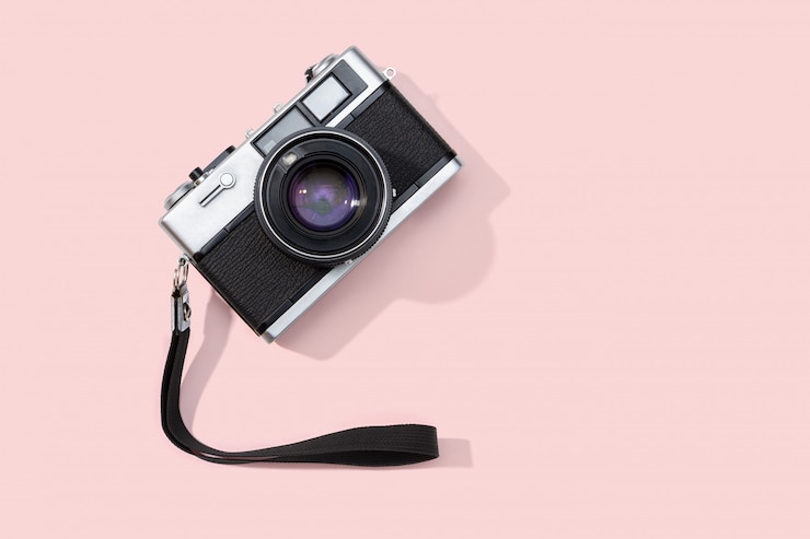 Foto plat leggen filmcamera geïsoleerd op roze achtergrond. kopieer ruimte