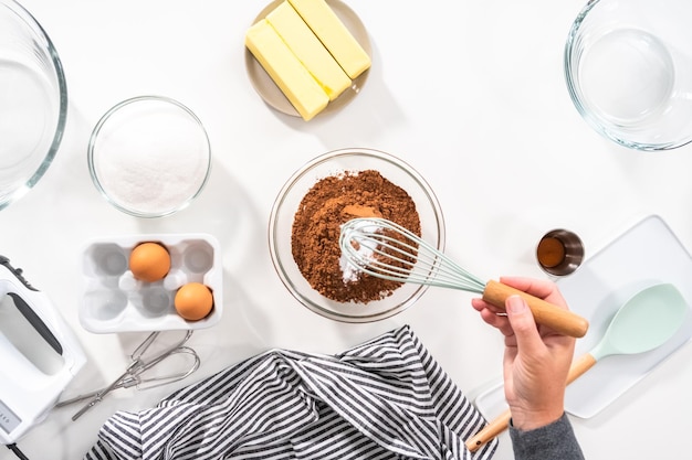 Plat leggen Ingrediënten mengen in een glazen mengkom om chocoladekoekjes te bakken