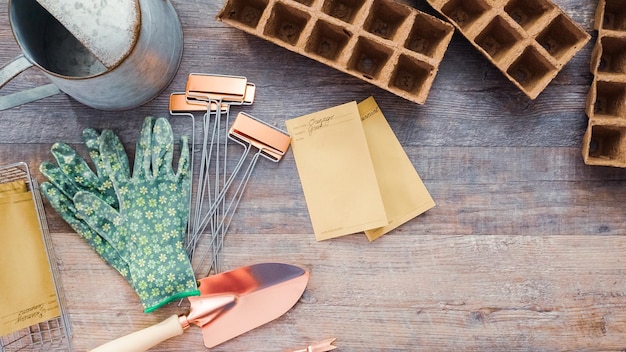 Plat leggen. Klein tuingereedschap is klaar voor het plantseizoen in de lente. Inclusief tuinhandschoenen, schep, gieter en plantenlabels.