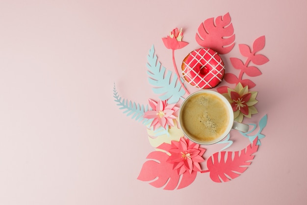 Plat leggen met kopje koffie en roze donut, moderne origami papercraft bloemen kopie ruimte