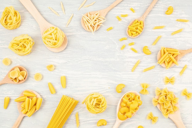 Plat leggen met verschillende soorten traditionele Italiaanse pasta. Penne, tagliatelle, fusilli, farfalle, spaghetti en anderen. Traditioneel Italiaans cusine-concept. Bovenaanzicht