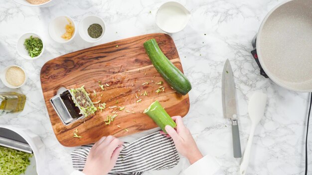 Plat leggen. Stap voor stap. Biologische courgette versnipperen om courgettecakes te maken.