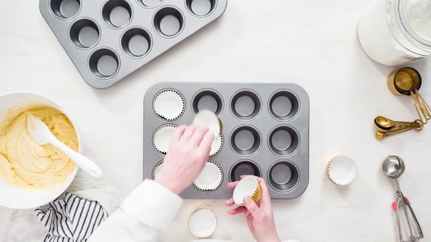 Plat leggen. Stap voor stap. Cupcakevormpjes op de cupcakevorm plaatsen om vanillecupcakes te bakken.