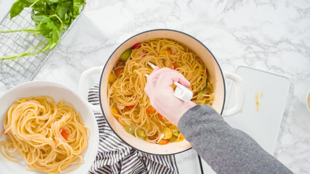 Plat leggen. Stap voor stap. Een eenpanspasta op een wit pastabord serveren.